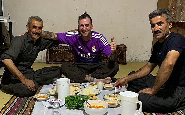 Imagen principal - Santiago Sánchez Cogedor ha atravesado 11 países conociendo diferentes culturas y disfrutando del camino. Cada día ha sido una experiencia, dice, desde comer sentado en el suelo hasta personalizarse una camiseta con un adolescente kurdo, siempre acompañado de su carro con la bandera de España.