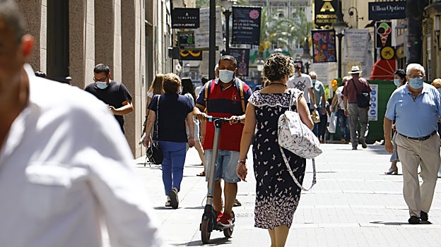 Un hombre circular por la calle Gondomar en su patinete eléctrtico