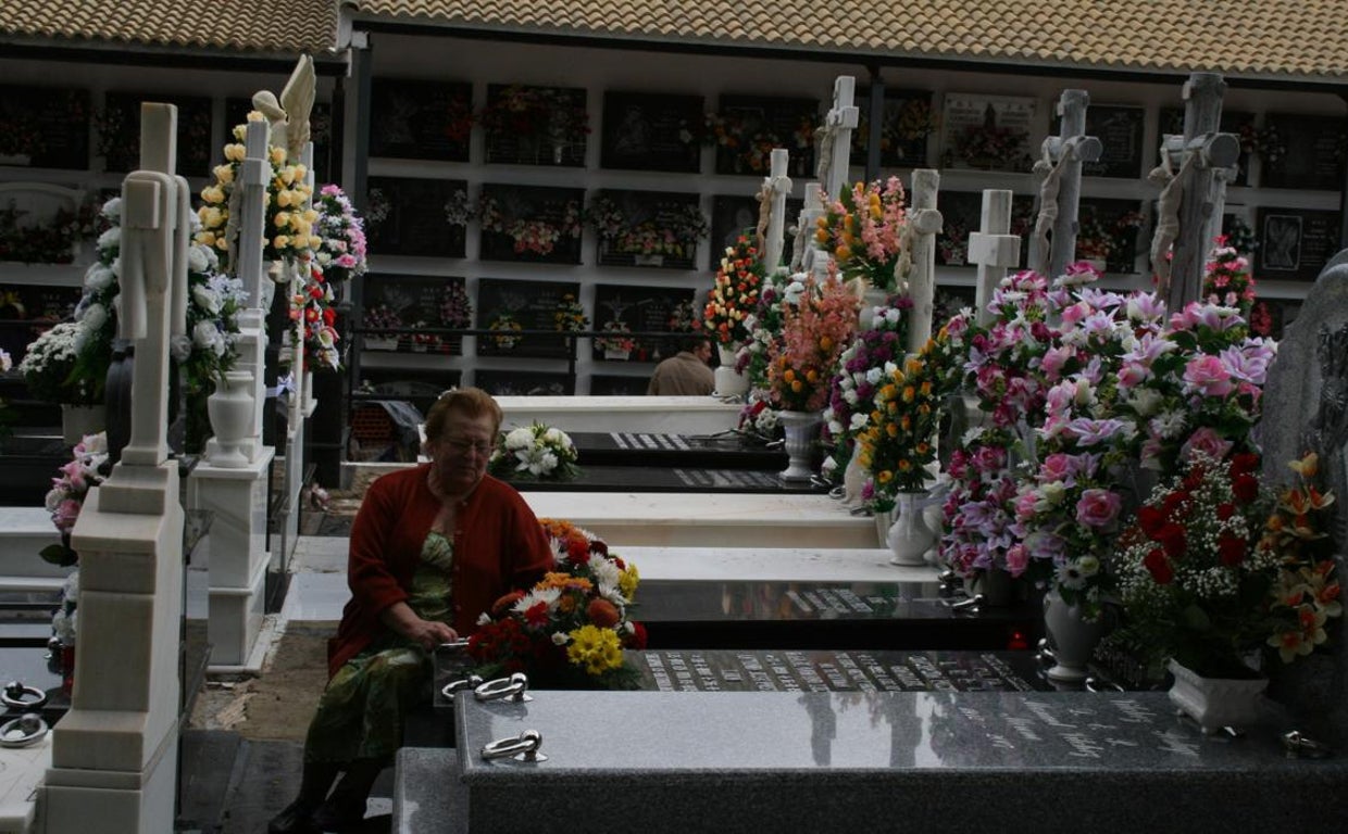 Una mujer junto a la tumba de un familiar