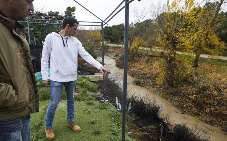 Imagen principal - Los vecinos muestran cómo el río invade sus casas (imagen principal) con fuertes lluvias y deja destrozos a su paso, con casetas de jardín (segunda imagen) y muros de viviendas derribados. 