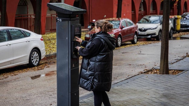 Una mujer saca el tique en uno de los nuevos parquímetros instalados