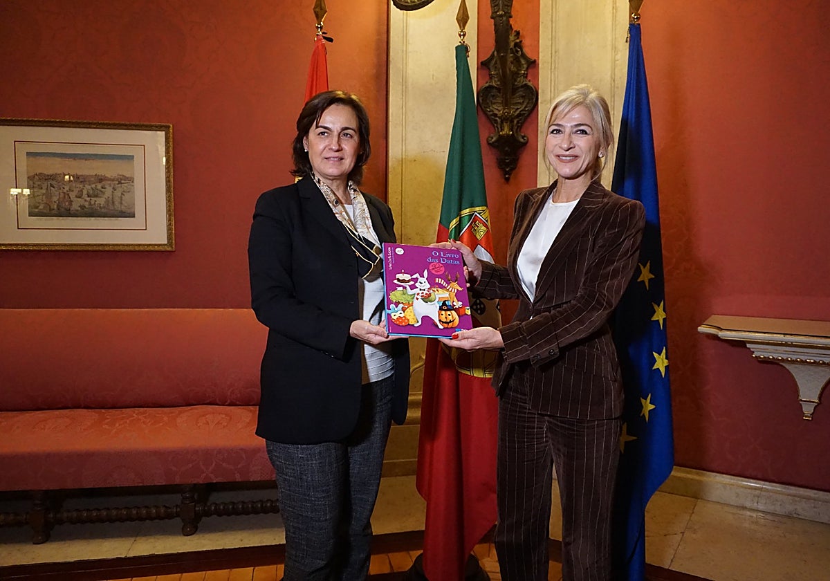 Patricia del Pozo, tras recibir este martes 20 de diciembre de manos de la Cónsul General de Portugal en Sevilla, Claudia Boesch, tres bibliotecas con 300 libros en portugués