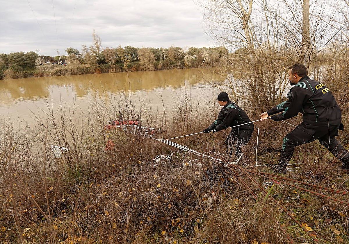 Agentes de la Guardia Civil amarran a la orilla el avión siniestrado
