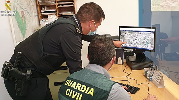 Dos agentes revisan información durante las operaciones desplegadas para el rescate de animales.