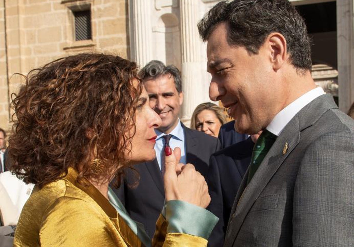 La ministra María Jesús Montero charlando con el presidente andaluz, Juanma Moreno, en un acto en Sevilla
