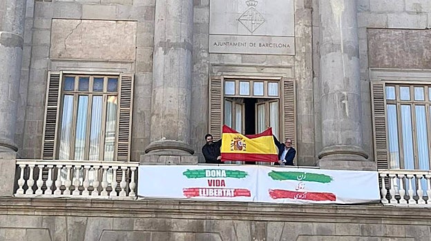 Momento en el que Josep Bou y Paco Sierra han desplegado la bandera de España desde el Ayuntamiento de Barcelona