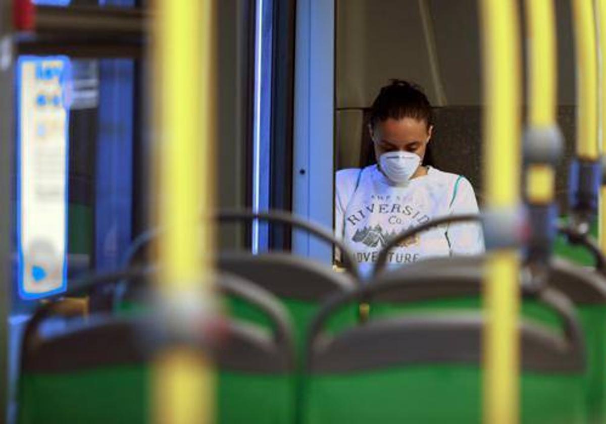 Una mujer en el autobús con la mascarilla