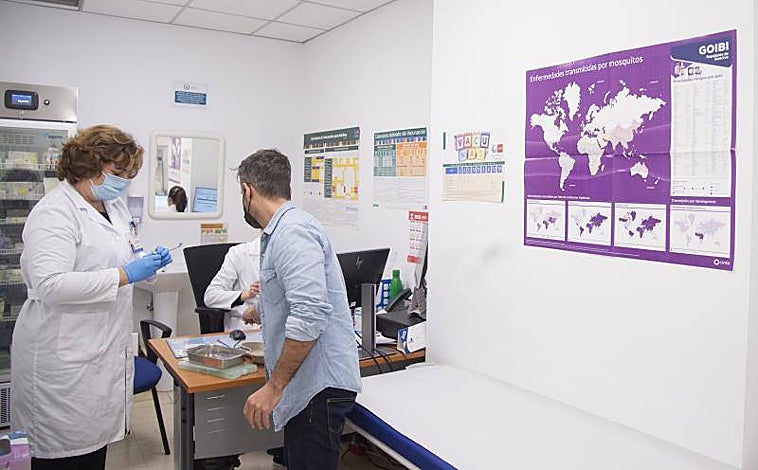 Imagen principal - Arriba, una enfermera atiende a un usuario del Centro de Vacunación ayer. Abajo, izq., las responsables del centro y la subdirectora general de Prevención y Promoción de la salud. Dcha, una vacuna subcutánea.