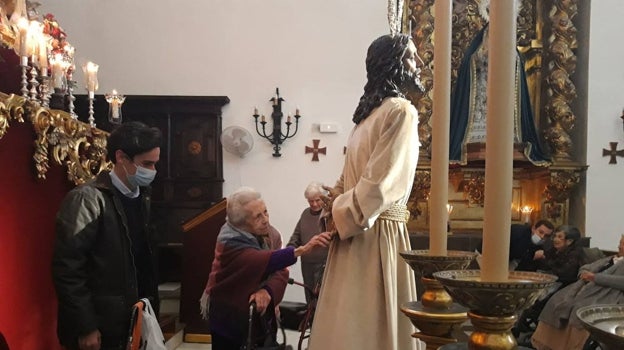 Una mujer de la residencia San Juan de la Cruz participa en el besamanos al Señor del Perdón, este sábado