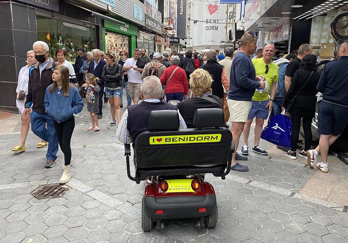 Jubilados y otros turistas en una calle comercial de Benidorm.