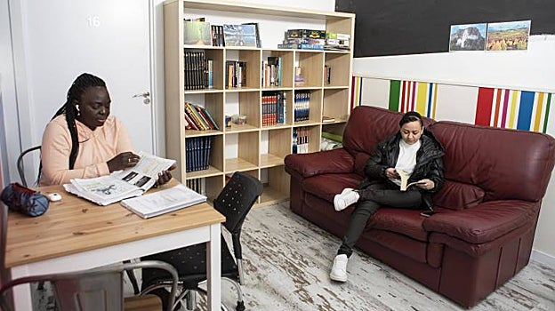 Ado estudia y Maira lee un libro en la pequeña biblioteca