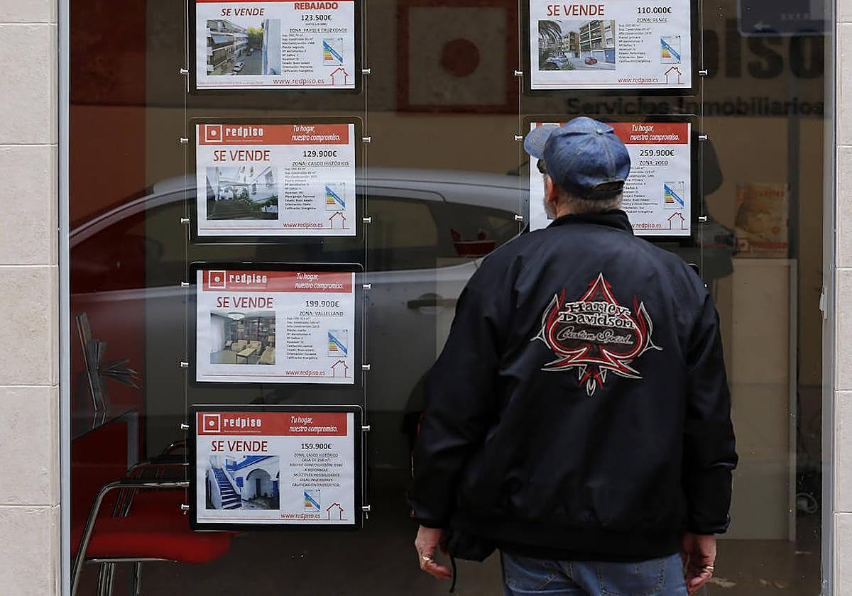 Un hombre mira pisos en venta en una inmobiliaria de Córdoba