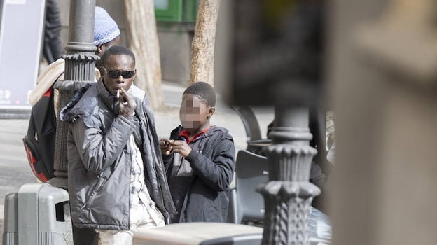 Un hombre, junto a un niño, en la zona de trapicheo de drogas de la plaza de Lavapiés