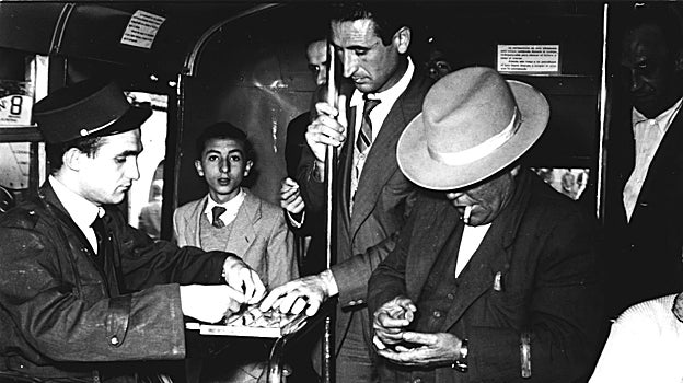 Un cobrador dentro de un vehículo junto a clientes