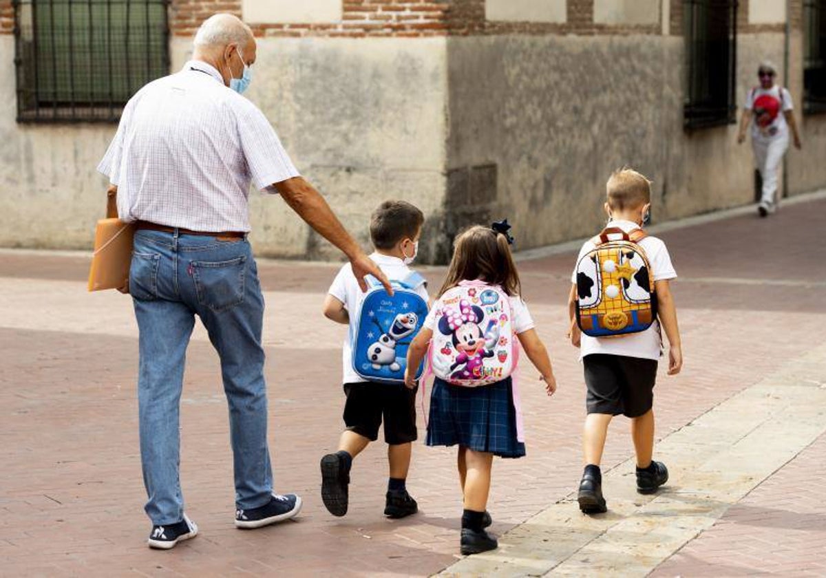 Un abuelo lleva a sus nietos al colegio en una imagen de archivo