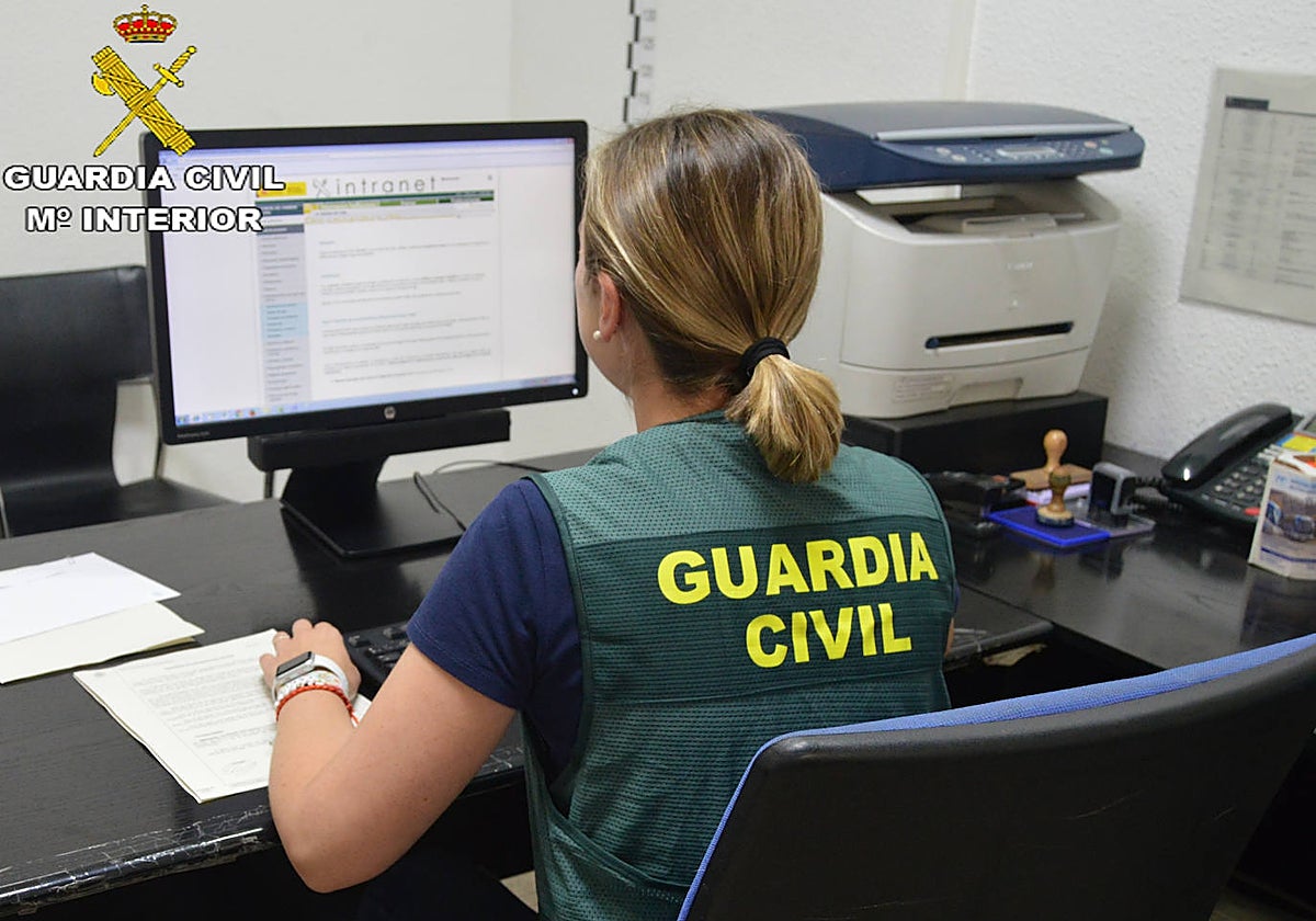 Imagen de una agente de la Guardia Civil frente a un ordenador
