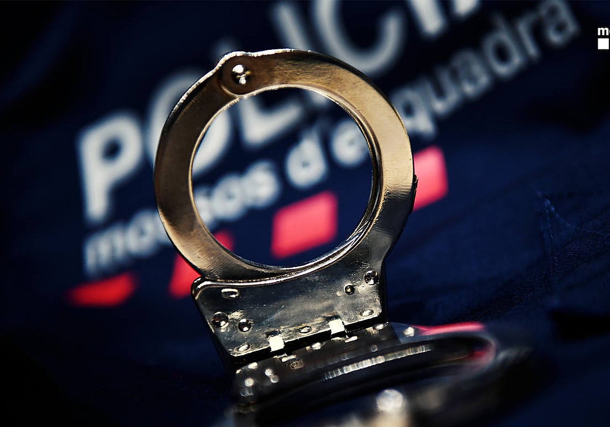 Unas esposas, junto a un uniforme de la Policía catalana