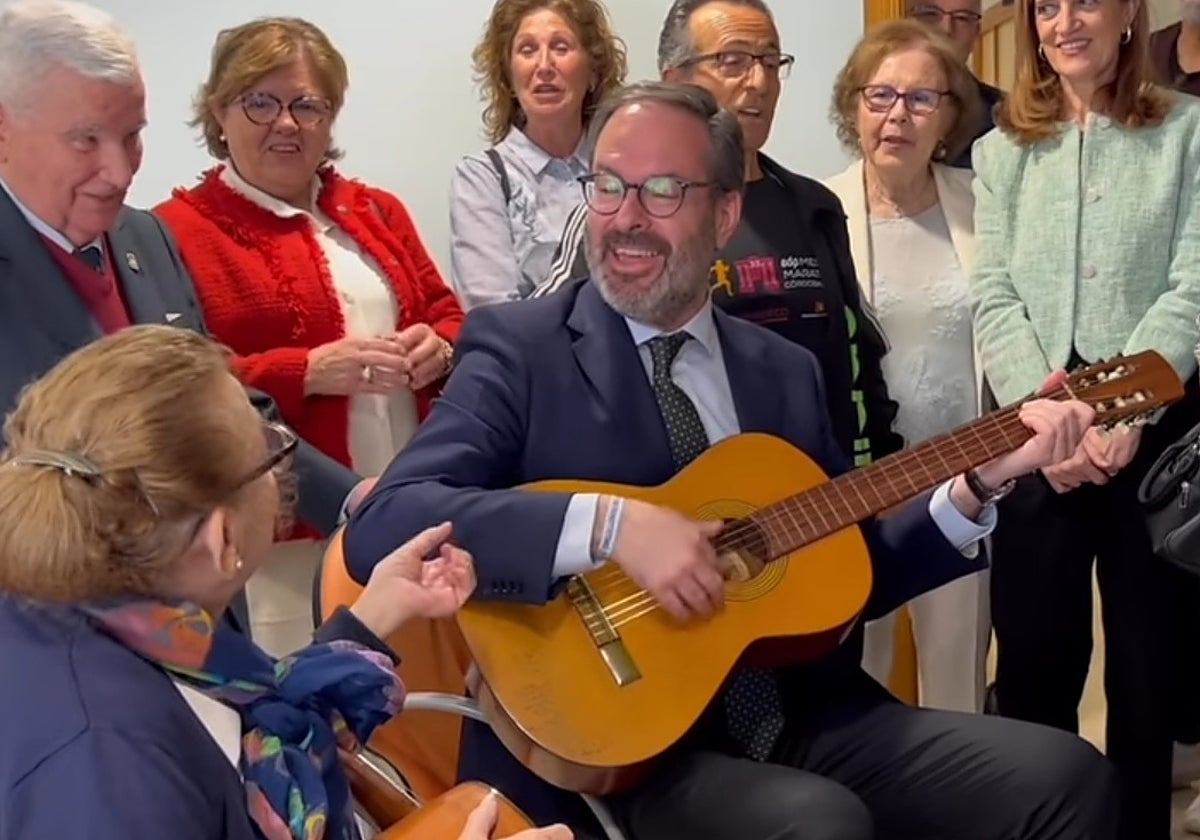 Adolfo Molina toca la guitarra y canta junto con una mujer en un centro de participación activa de Córdoba