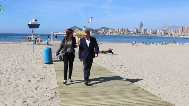 El alcalde, Toni Pérez, y la concejal de Playas, Mónica Gómez, caminan por una pasarela.