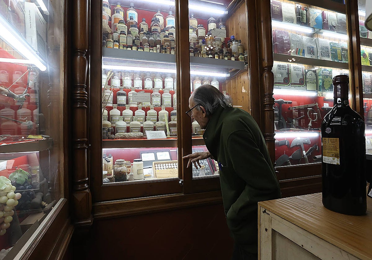El propietario de una bodega de vinos ojea una de la vitrinas, en una imagen de archivo