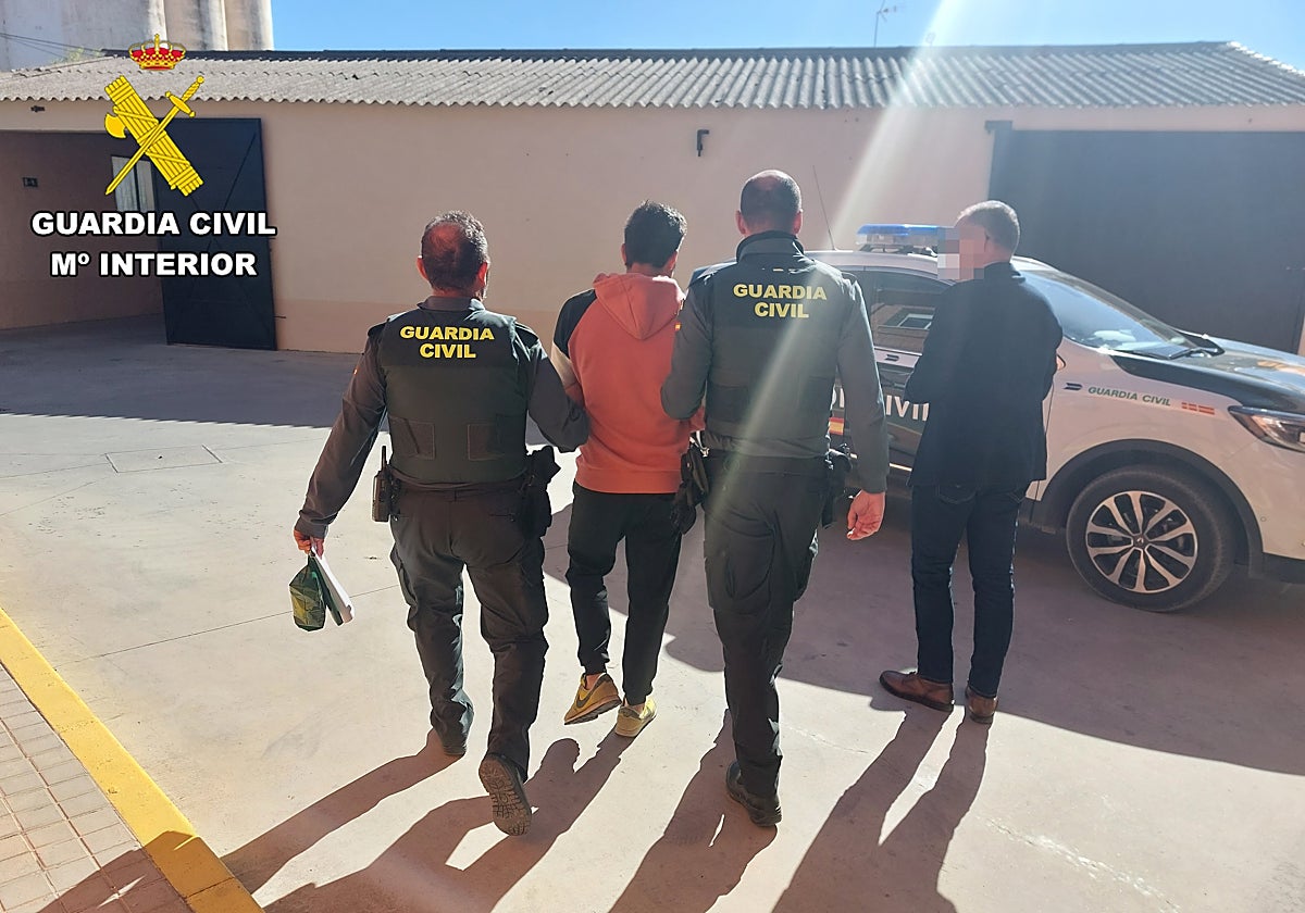 El detenido, custodiado por dos agentes uniformados