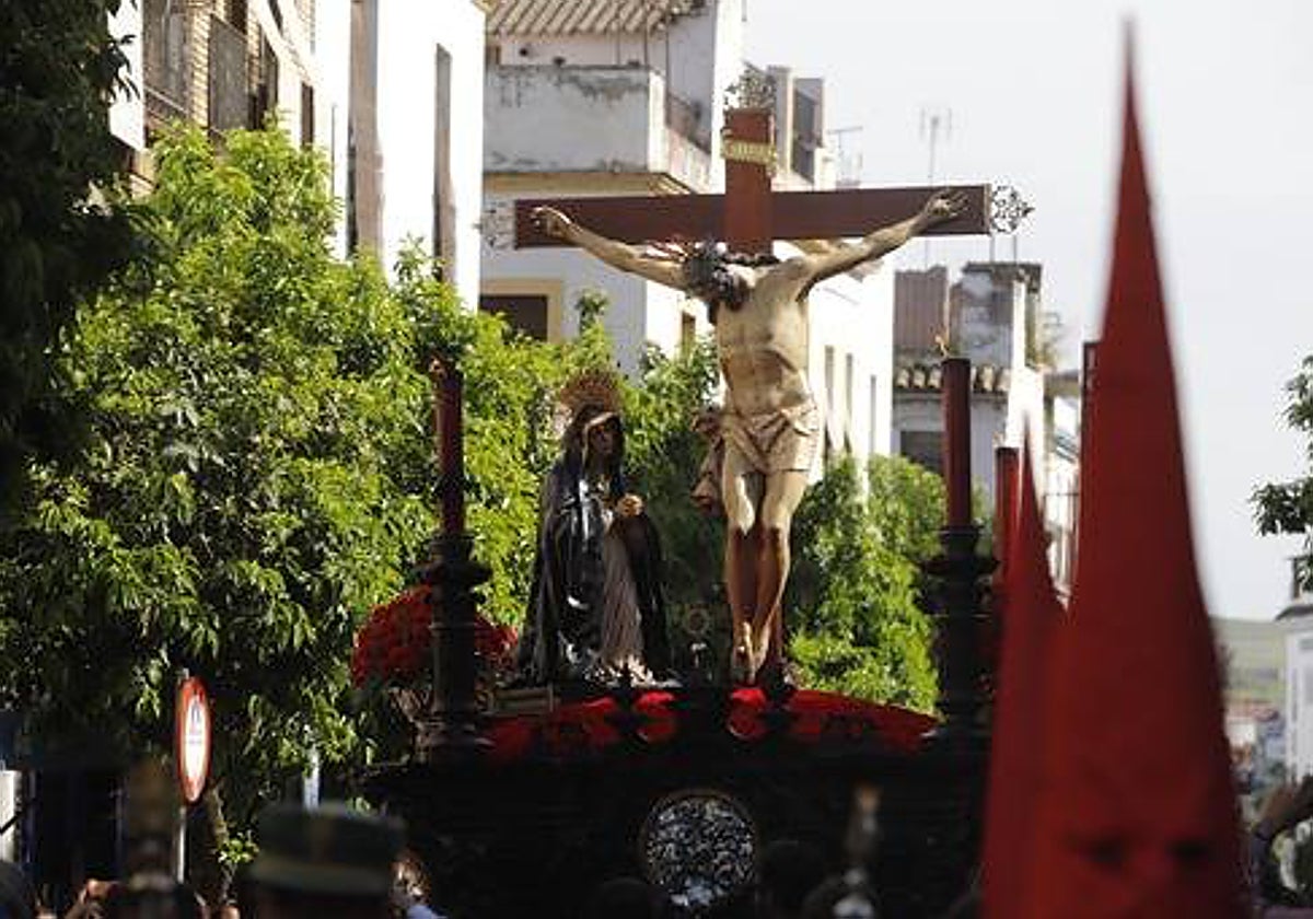 El Cristo de la Caridad, con sus eternos claveles rojos, por la calle San Fernando, el Jueves Santo