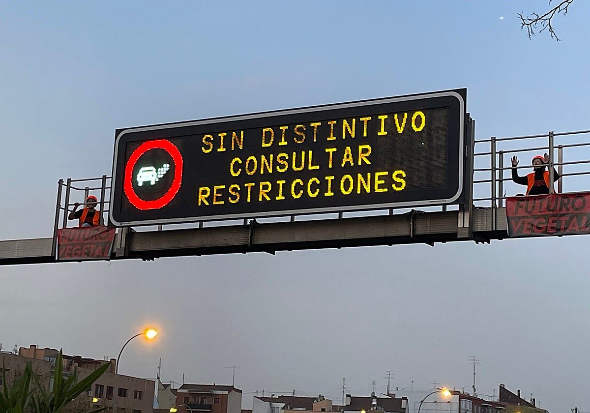 Dos activistas, subidas al panel informativo de la M-30