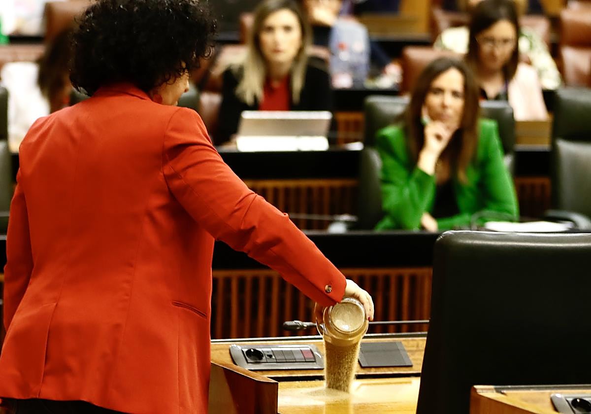 La diputada Maribel Mora, en el momento de verter arena en el escaño del presidente de la Junta