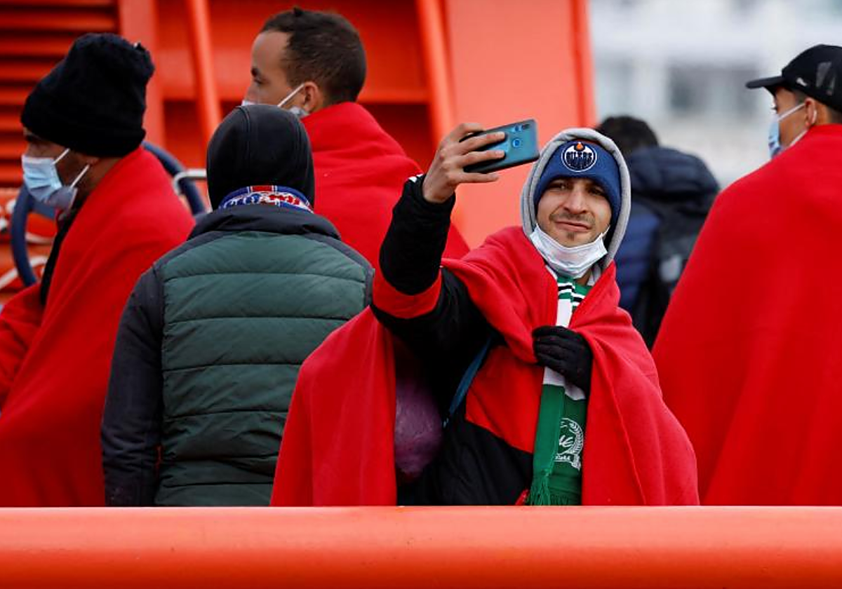 Un migrante se saca un selfie en su desembarco en el muelle dee Arguineguíin