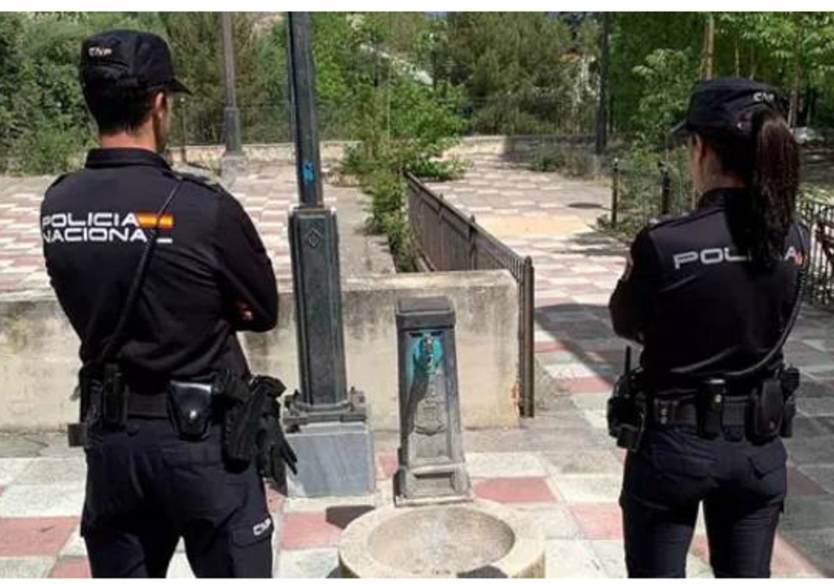 Imagen de dos agentes de la Policía Nacional junto a la fuente de agua robada en Alcoy