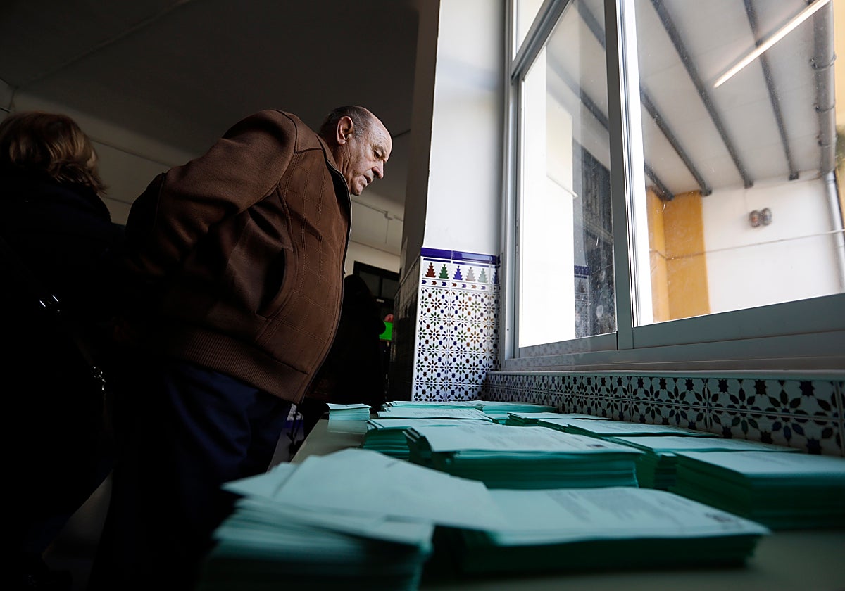 Un ciudadano delante de las papeletas electorales