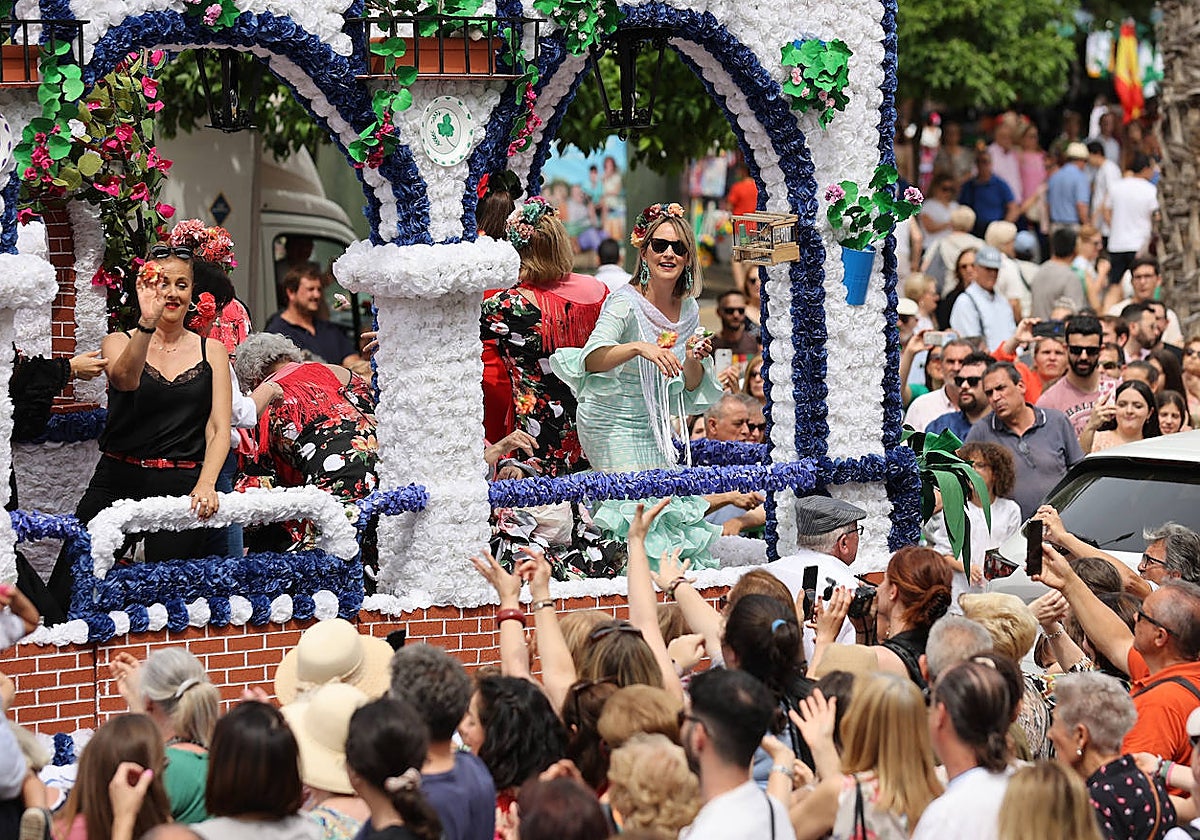 Dos mujeres lanzan claveles desde una carroza en la Batalla de las Flores de Córdoba