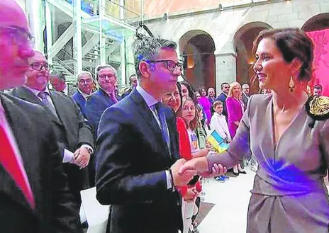 Imagen secundaria 1 - 1. Los ministros de Presidencia y Defensa llegaron juntos a Sol. Bolaños, con Enrique López en la foto, tenía asiento reservado pese a no estar invitado // 2. El saludo de Isabel Díaz Ayuso a Bolaños fue rápido y frío. El ministro solo tuvo tiempo de cogerle un momento el brazo // 3. El ministro, que se ausentó unos minutos durante el discurso de Ayuso, acusó al Gobierno regional de «crispar» y provocar una polémica «artificial».