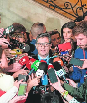 Imagen secundaria 2 - 1. Los ministros de Presidencia y Defensa llegaron juntos a Sol. Bolaños, con Enrique López en la foto, tenía asiento reservado pese a no estar invitado // 2. El saludo de Isabel Díaz Ayuso a Bolaños fue rápido y frío. El ministro solo tuvo tiempo de cogerle un momento el brazo // 3. El ministro, que se ausentó unos minutos durante el discurso de Ayuso, acusó al Gobierno regional de «crispar» y provocar una polémica «artificial».