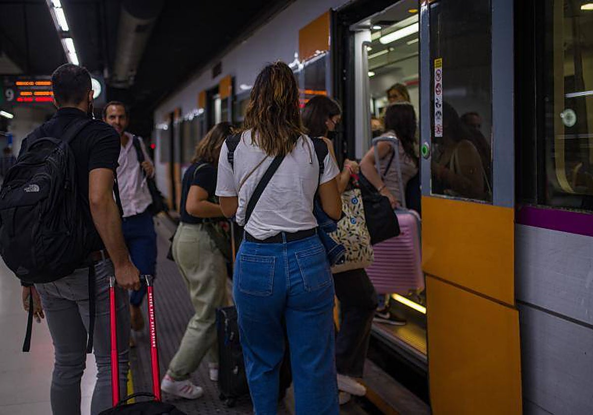 Usuarios, esperando ara poder subir a un tren en la estación de Sants