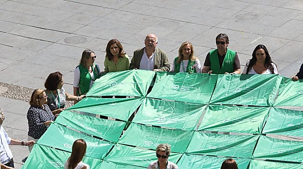 Despliegue de la bandera de la AECC en la Plaza de las Tendillas este jueves