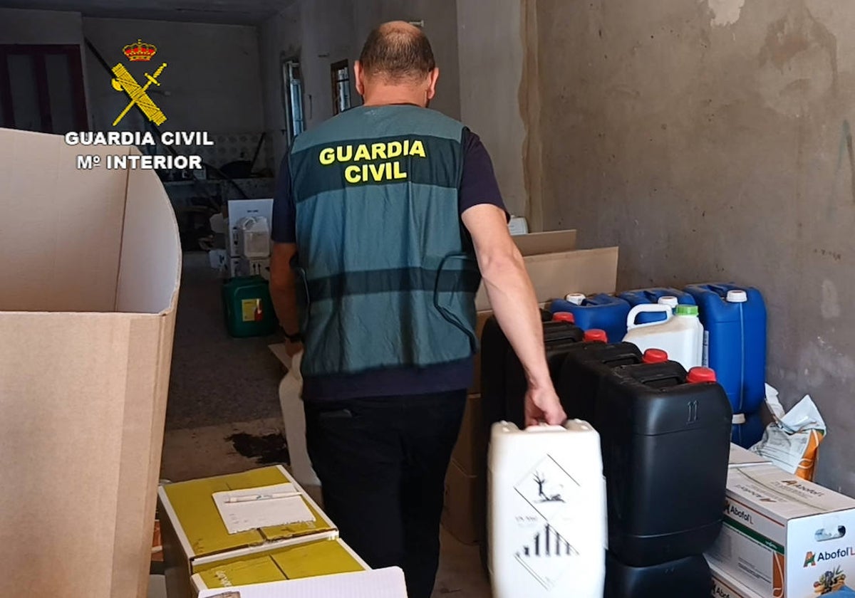 Imagen de un guardia civil con el material incautado en la operación Butrono