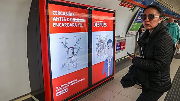 Una usuaria del metro camina junto a uno de los paneles publicitarios