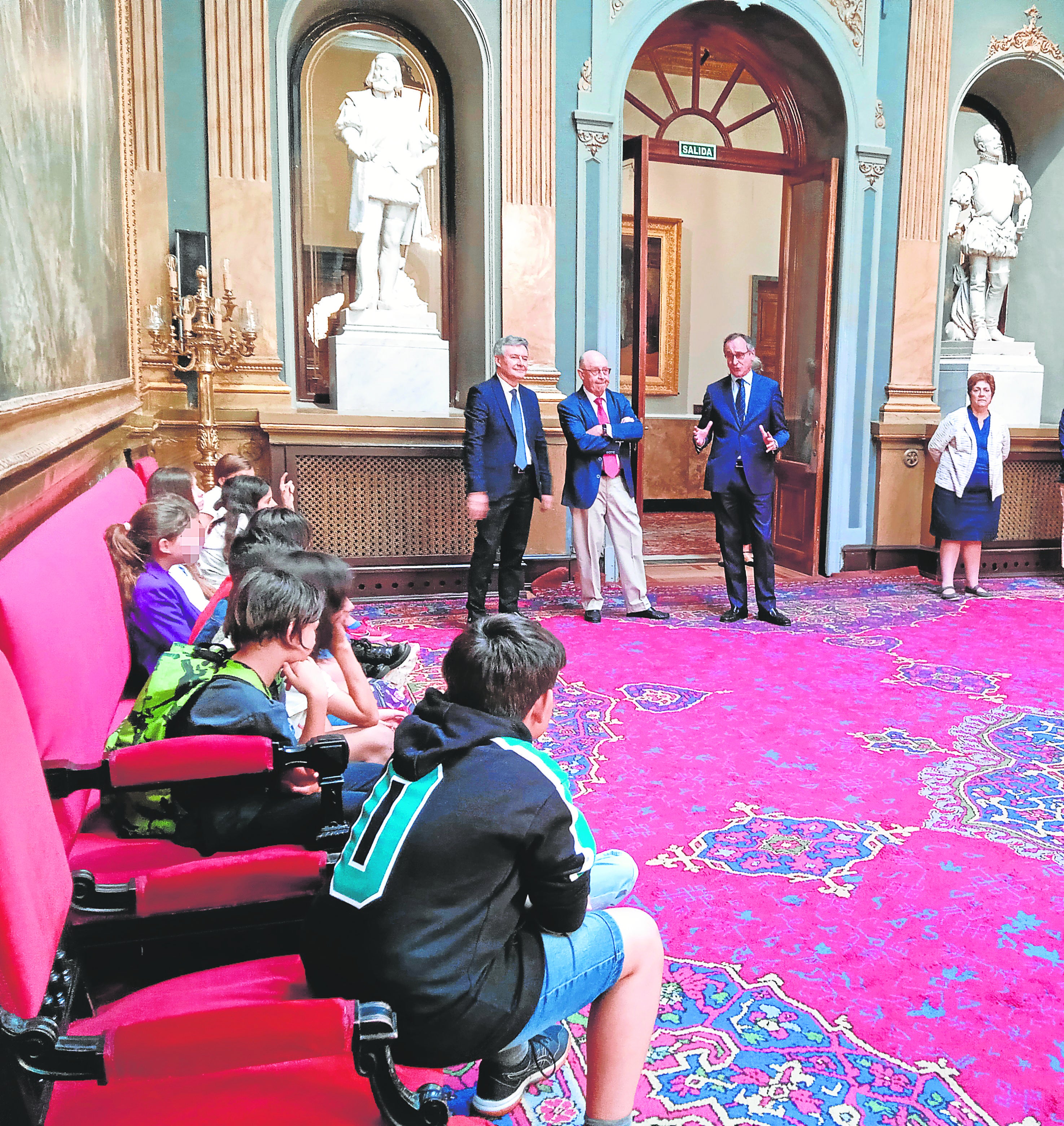 De pie, de izquierda a derecha, Rubén Moreno, Cristóbal Montoro, Alfonso Alonso y una guía del Senado en un momento de su encuentro con alumnos de sexto del colegio público La Navata (Galapagar)