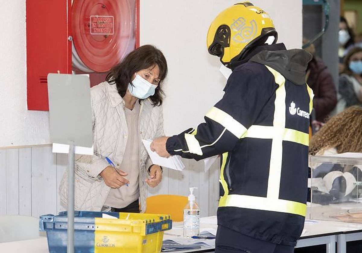 Un trabajador de Correos entrega los votos emitidos por correo