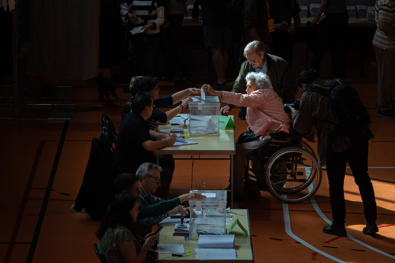 Una mujer mayor en silla de ruedas ejerce su derecho al voto en la Escola Grèvol, este domingo en Barcelona, Cataluña