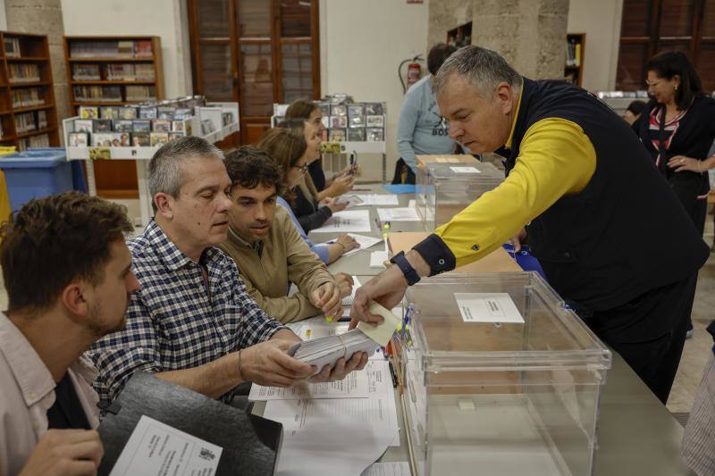 Un cartero entrega los votos emitidos por correo en una mesa electoral de Valencia