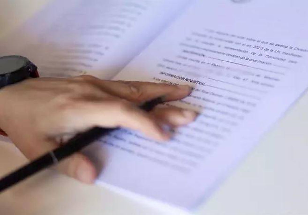 Una mujer, firmando la escritura de compraventa de una hipoteca en una imagen de archivo