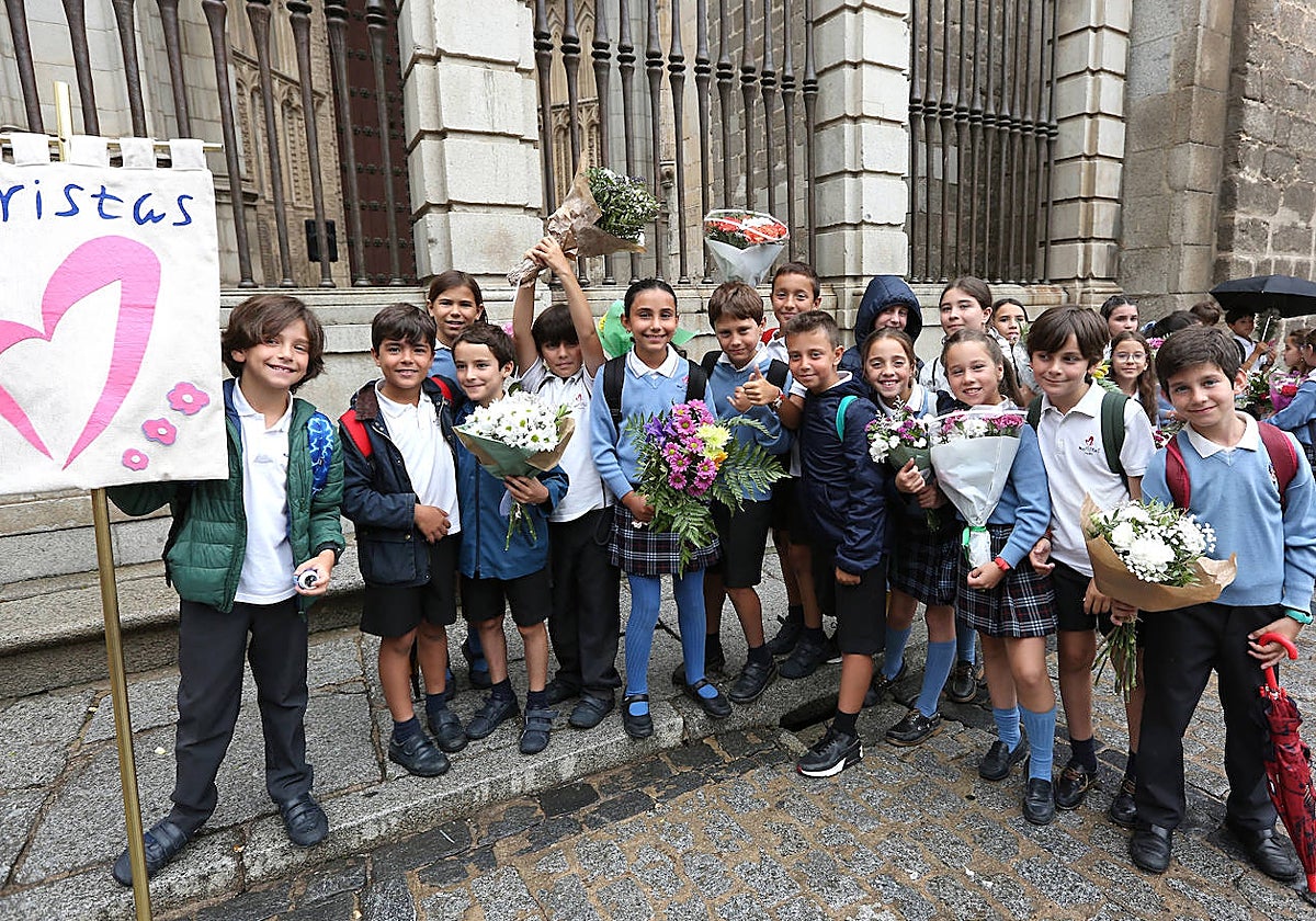 Un grupo de escolares con ramos de flores posan para ABC