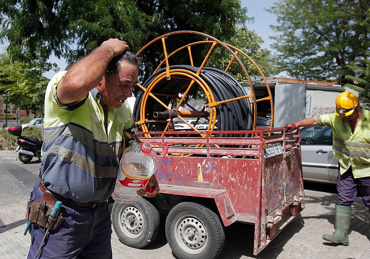 Un obrero se refresca con agua
