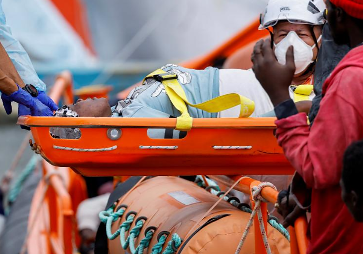 Los servicios de emergencia ayudan a una mujer rescatada en el muelle de Arguineguín este lunes
