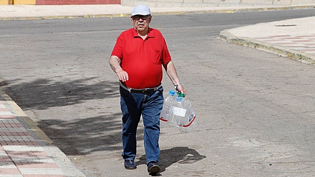 Un hombre se dirige a recoger agua