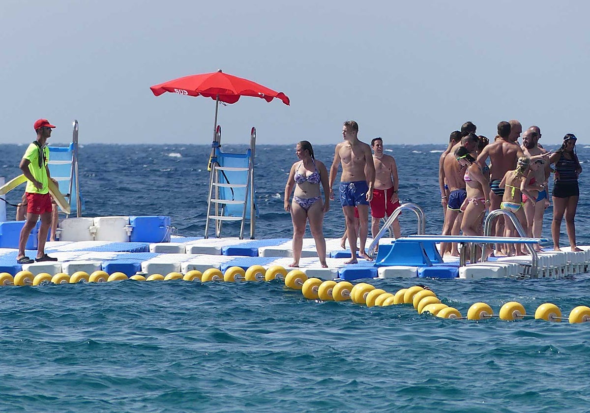 Turistas en una plataforma de juegos flotantes en la playa de Benidorm