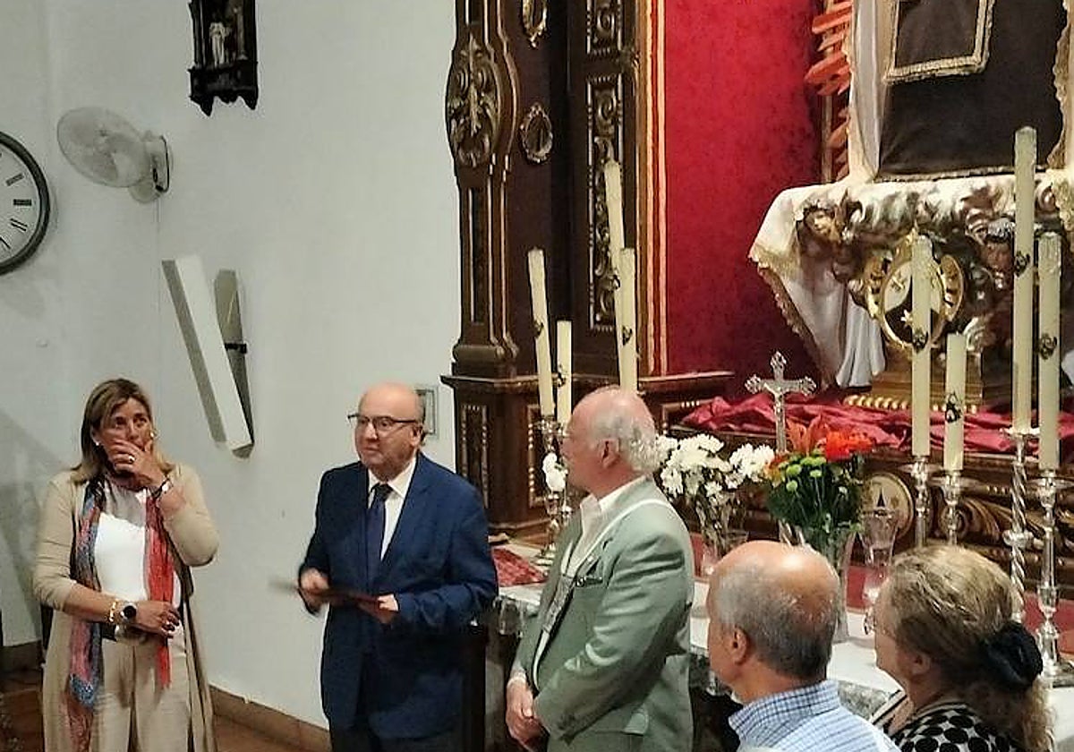 Luis Martín, en el centro, recibe las pastas del pregón, a los pies de la Virgen junto a Amelia Caracuel, que será su presentadora, y el hermano mayor, Juan Manuel Vargas