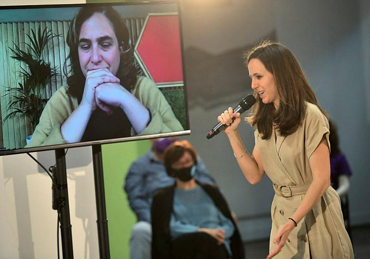 Ione Belarra y Ada Colau (en la pantalla), en un acto político de Podemos a un mes de las elecciones madrileñas de 2021